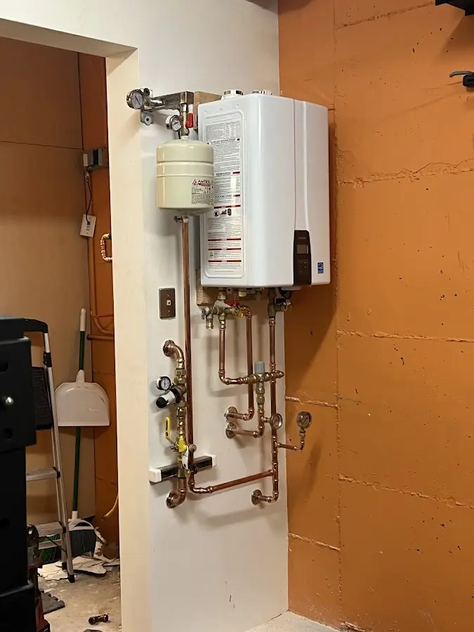 Plumbing technician inspecting water heater connections in Stratford